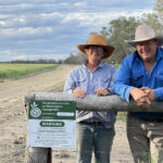 Lisa and Andrew at the gate of their wheat field. The biosecurity notice is a certified organic regulation